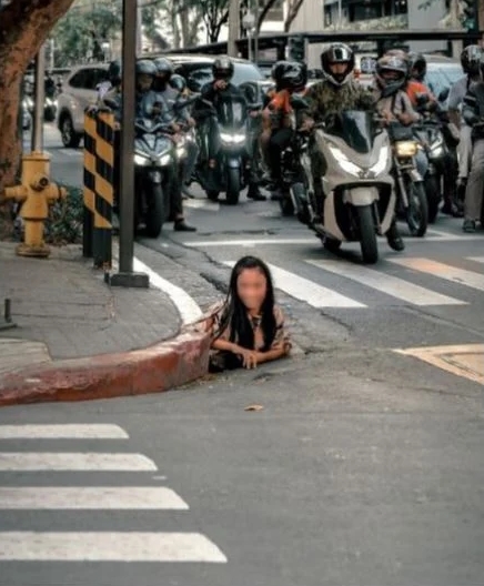 สาวคลานออกมาจากท่อระบายน้ำกลางแยก